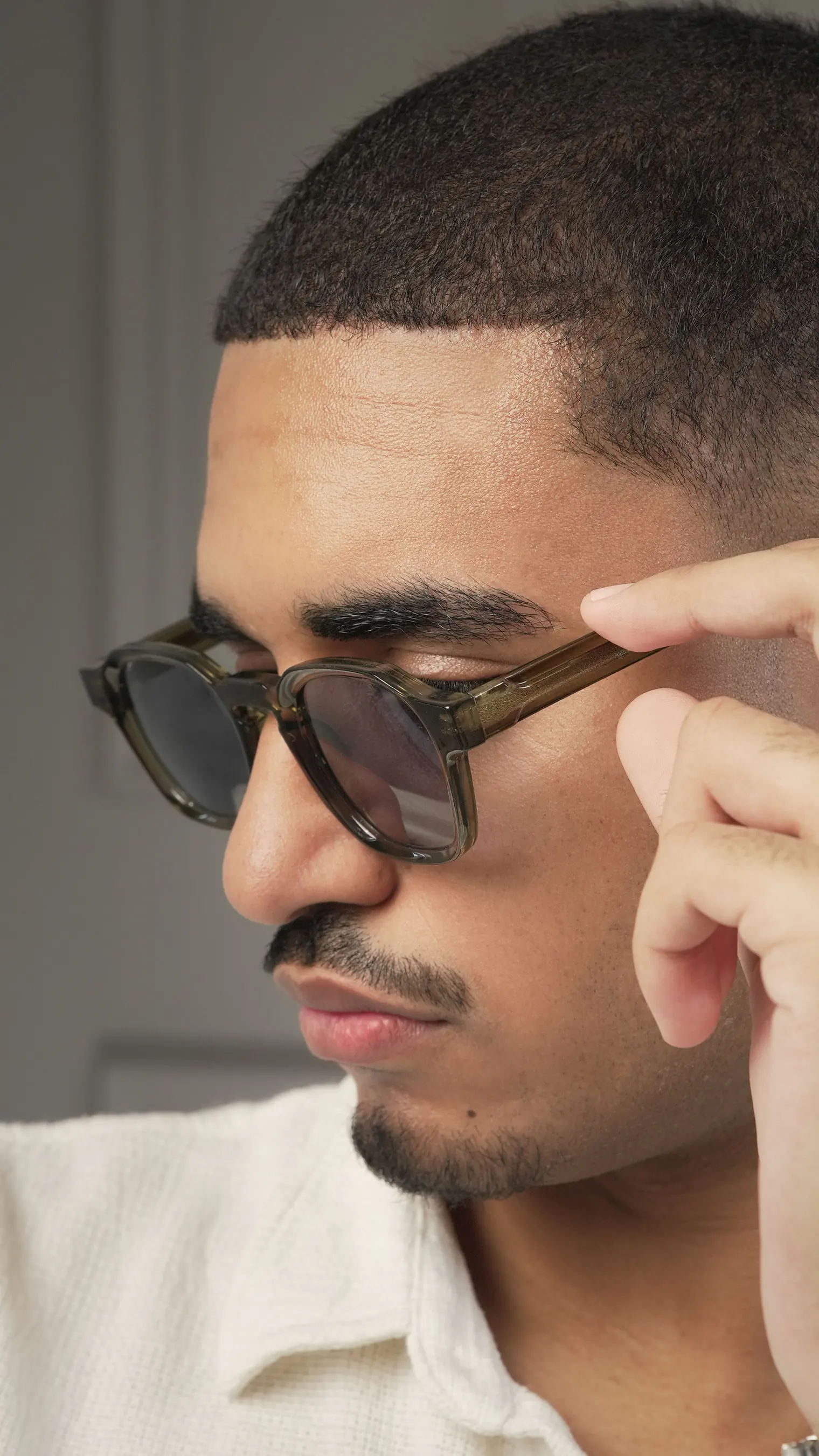 A model wearing CORP sunglasses in Green-Grey