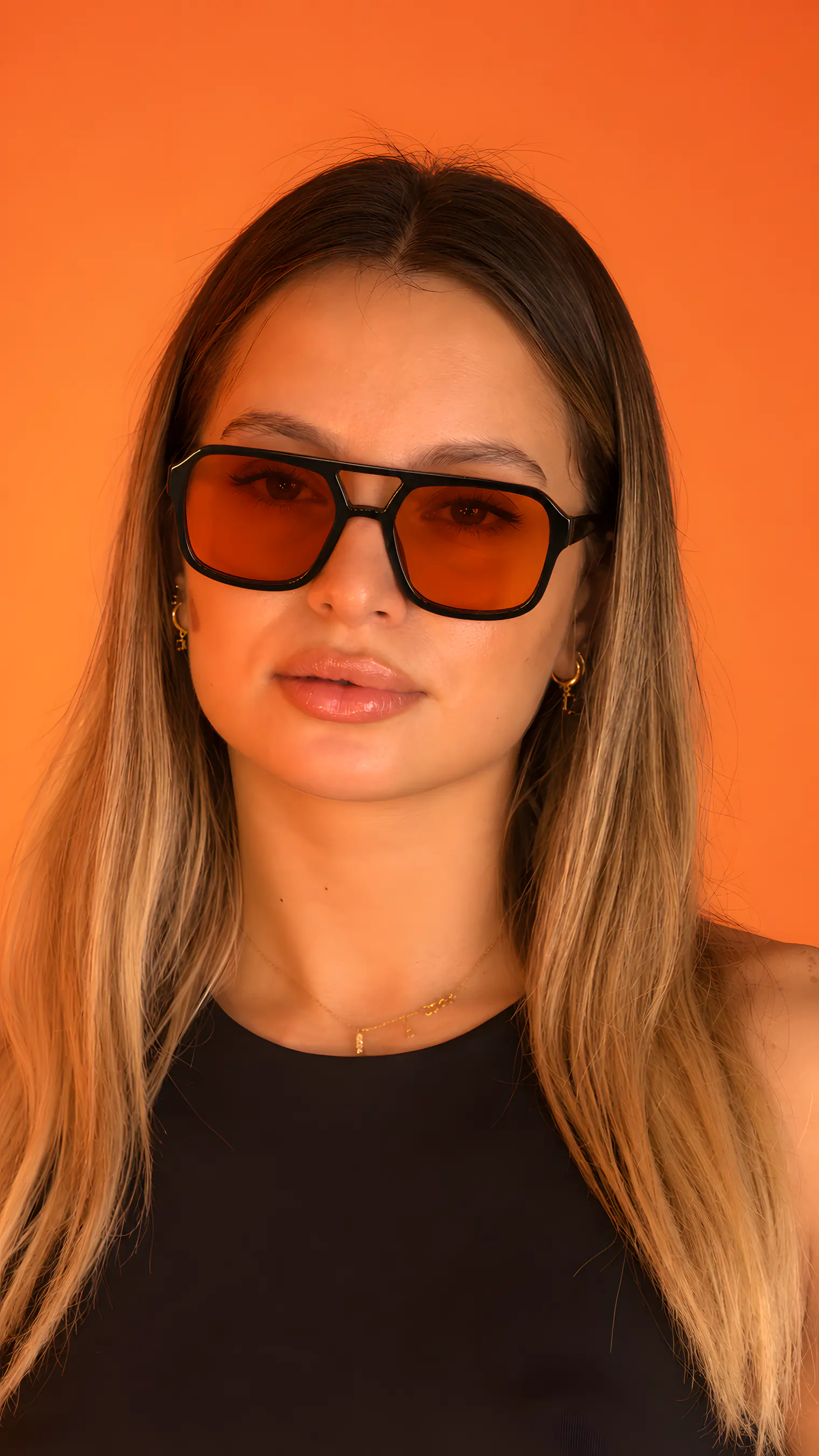 A model wearing PABLO sunglasses in Orange